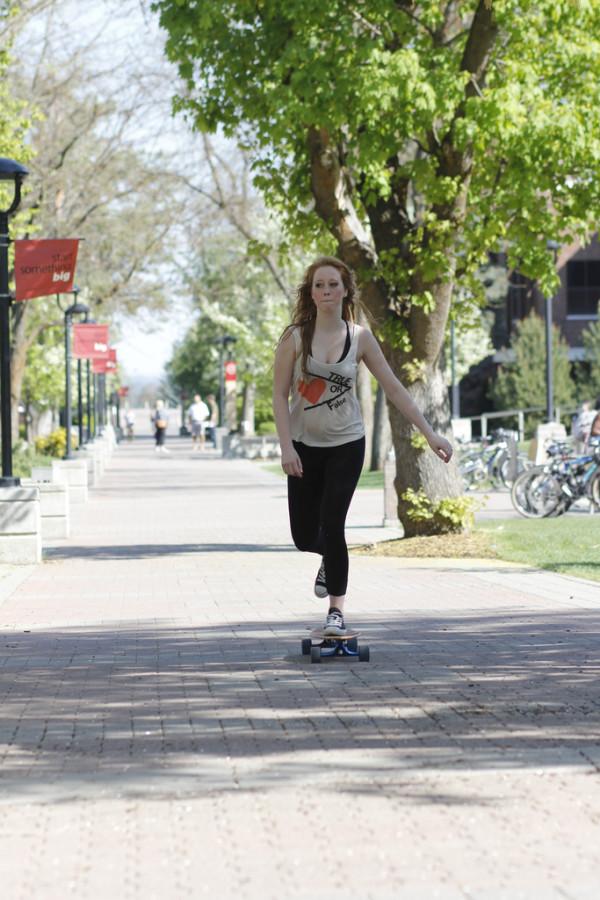 Hanna Fleming uses her longboard to commute to class. Photo by: Anna Mills