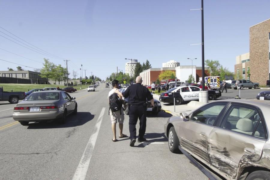 Saleh Alsudais is consoled by a Cheney Police officer after Alsudais discovered that his car was involved in a collision outside
Cadet Hall. His car was one of five cars damaged May 9.