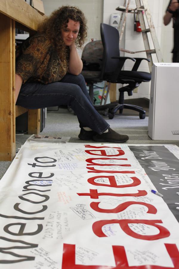 Amy Meyer plans where she will sign the banner. Meyer was editor-in-chief for volumes 63 and 64.