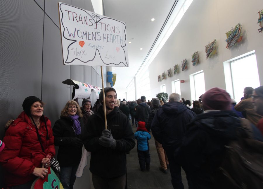 Cameron Gibbons shows support for The Women's Hearth as the crowd leaves the Spokane Convention Center to begin their march through downtown Spokane.