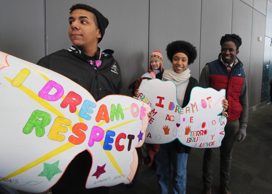 EWU student Kenny Applewhaite, left, and his sister Shanice hold signs as people leave the Spokane Convention Center to begin their march through downtown. 