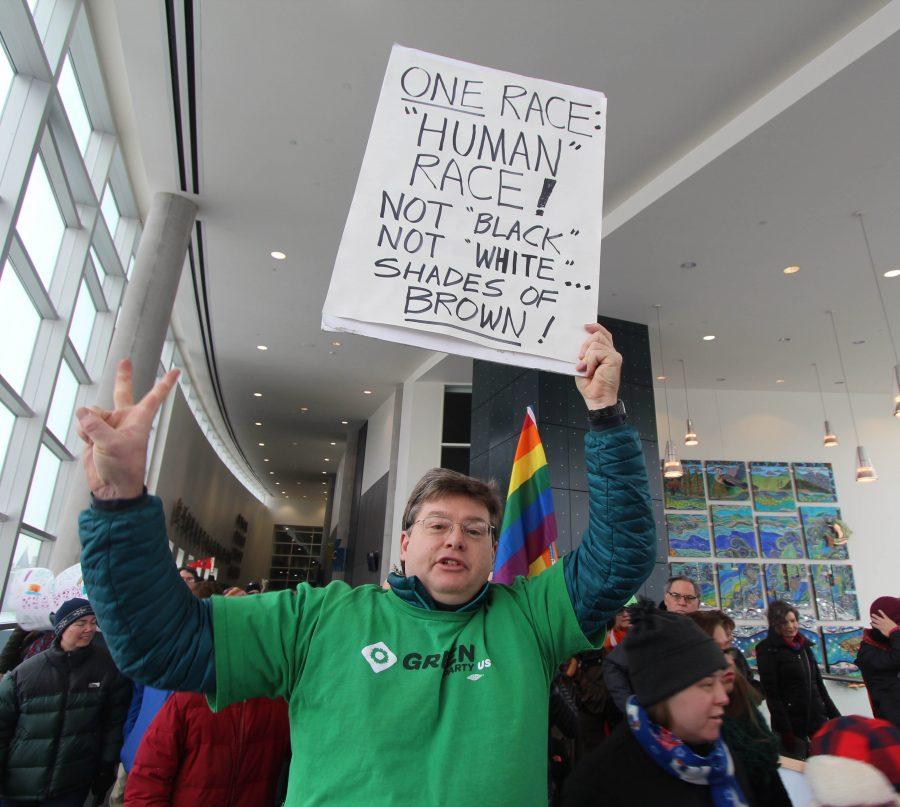 Jax Clay, supporter of the Spokane Green Party, holds up a sign and chants as he leaves the Spokane Convention Center to begin his march through downtown.