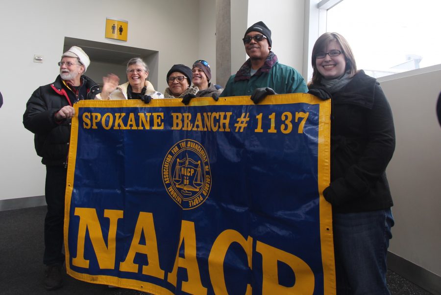 (Left to right) Suzi Hokonson, Fay Baptiste, Curtis Robinson, Joseph Baptiste and Libby Palmer hold up a sign supporting Spokane NAACP as people leave the Spokane Convention Center to begin their march through downtown. 