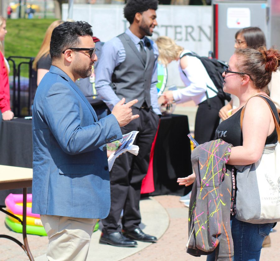 Jaime Olguin, ASEWU presidential candidate, speaks with a student at the campus mall. 