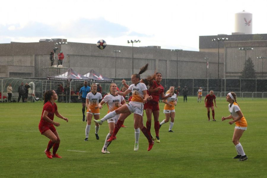 EWU junior forward Sariah Keister (red, No. 2) and NDSU senior forward Laura Powell (white, No. 7) go for a header on a rainy Friday evening in Cheney. Keister scored EWUs only two goals in a 4-2 loss. 